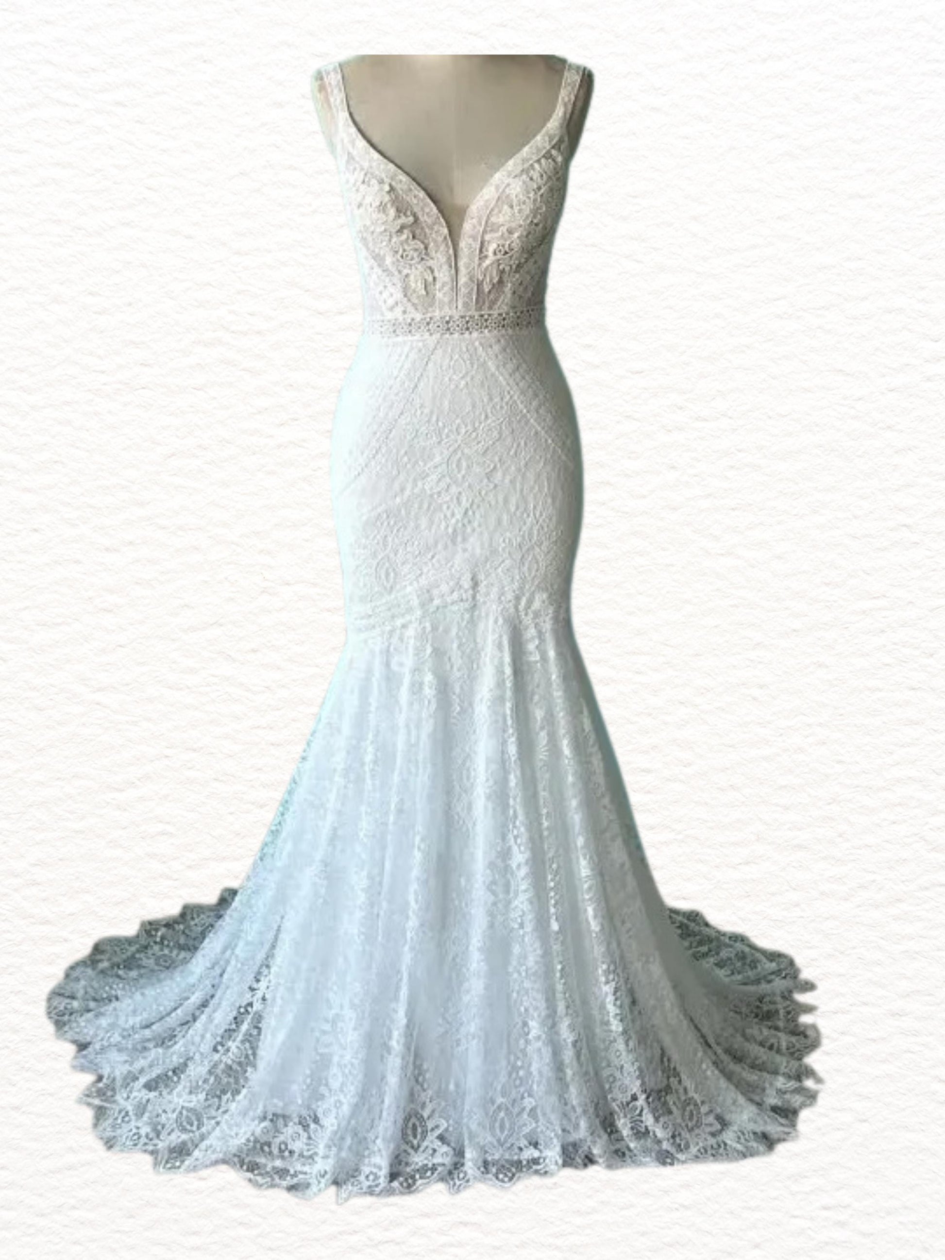 May include: A white, floor-length wedding dress with a mermaid silhouette. The bodice features a deep V-neckline and delicate lace detailing. A thin beaded belt accentuates the waist. The skirt flares out into a flowing train.